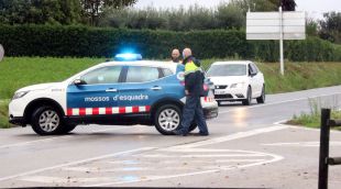 Pla mitjà d'una parella de Mossos d'Esquadra tallant una carretera