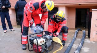 Efectius dels Bombers instal·lant una bomba per retirar aigua dels habitatges inundats de Vilatenim