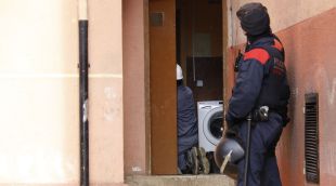 Dos agents protegint a dos dels tècnics d'Endesa que estan revisant els comptadors punxats a Font de la Pólvora