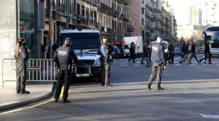 Dos agents de la Guàrdia Urbana de Barcelona, amb dos mossos a darrere, controlen els vehicles que volen entrar a la Rambla