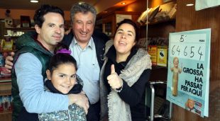 La propietària de l'estanc número 4 de Banyoles amb la seva família i un client celebrant que han donat un 5è premi