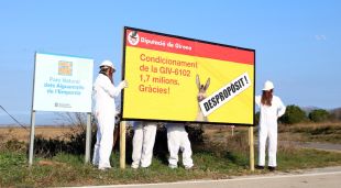 Membres de la IAEDEN amb el cartell de denúncia que han penjat a la carretera