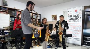 Dos dels estudiants de saxo del projecte Música a l'Est amb el professor en un assaig