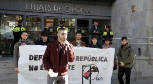 El primer investigat citat a declarar amb el micròfon i darrere alguns dels detinguts per les mobilitzacions de l'aniversari de l'1-O