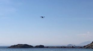 L'avioneta biplà abandonant la cala Almadrava després de les acrobàcies