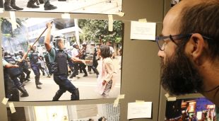 Un visitant mirant algunes instantànies de càrregues a la mostra d'Olot