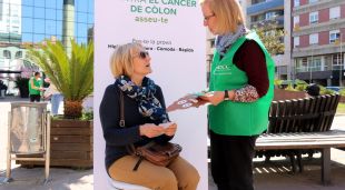 Una voluntària informant una dona, aquest matí