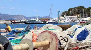 El moll del Port de la Selva amb xarxes i un pescador feinejant aquest matí