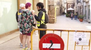 Un vigilant de seguretat explicant a uns turistes que no poden accedir al casc antic