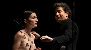 Primer pla de María Valverde amb Gustavo Dudamel dirigint al fons