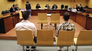 D'esquenes, els dos susposats integrants d'un grup criminal que robava a empreses. Foto del judici a l'Audiència de Girona