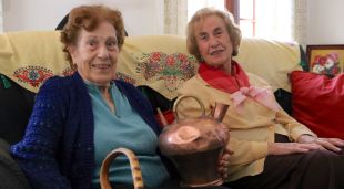 La Mercè Figa (esquerra) i la Maria Figa mostrant un canti que va patir l'impacte d'un tiroteig al final de la Guerra Civil