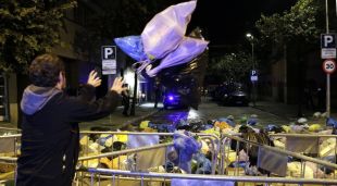 Un manifestant llançant deixalles davant la subdelegació de Girona