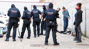 Agents dels Mossos escorcollant algunes persones a l'aparcament proper a l'Ap-7 a la Jonquera