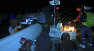 Manifestants amb una foguera i altres sopant al costat a l'AP-7 a la Jonquera