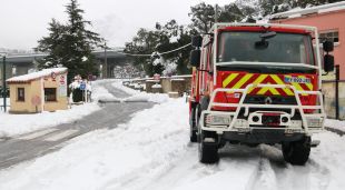 Un camió de bombers francès aparcat en una cantonada i de fons el Pertús totalment nevat
