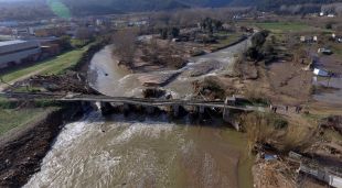 Pla general d'un pont esfondrat i una canonada trencada a Anglès a vista de dron