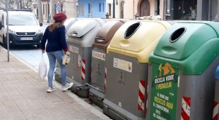 Una noia llançant les escombraries avui en una zona de contenidors de Sant Feliu de Guíxols
