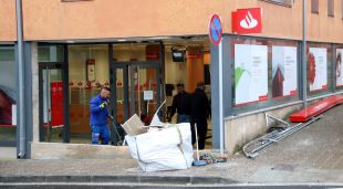 Un grup de treballadors a la sucursal bancària de Riudellots on uns encaputxats han encastat la plataforma d'una grua