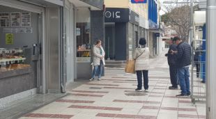 Algunes persones fent cua per entrar en un establiment de Platja d'Aro per comprar aliments