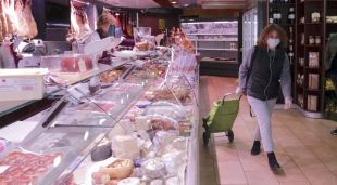 Una clienta d'una carnisseria de Girona, sortint de comprar i portant mascareta