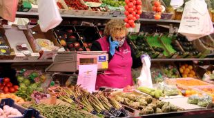 La propietària de Fruits Campllong atenent una comanda telefònica