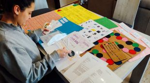 Una voluntària de Càritas preparant activitats diverses per a infants i joves que necessitin suport educatiu