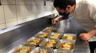 El xef de L'Aliança 1919 d'Anglès, Àlex Carrera, preparant diversos dels plats que el restaurant serveix a domicili