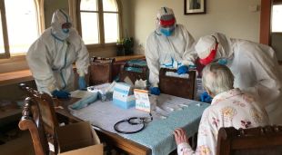 Sanitaris practicant una prova PCR a una anciana a casa seva
