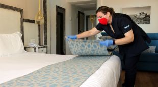 Una de les treballadores del Parkhotel San Jorge de Calonge, traient el plaid decoratiu del llit d'una de les habitacions