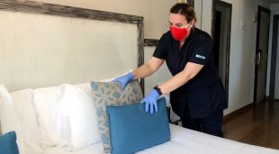 Una de les treballadores del Parkhotel San Jorge de Calonge, traient els coixins decoratius del llit d'una de les habitacions