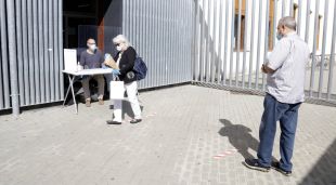 Cua amb distància de seguretat per recollir llibres en préstec a la biblioteca Salvador Allende de Girona