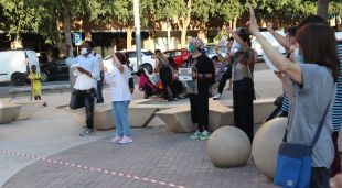 Diverses persones cantant els Segadors a la plaça de la Llibertat de Salt en la concentració