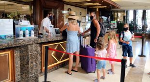 Una família estrangera realitzant el check-in a l'hotel Evenia Olympic de Lloret de Mar