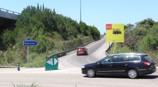 Rotonda a l'entrada de Blanes amb un vehicle pujant la rampa per accedir a la C-32