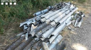 Pla detall de material d'uralita localitzat al Pla de l'Estany