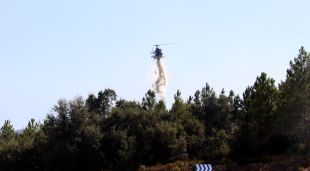Un helicòpter sobrevolant la zona afectada per l'incendi forestal a Caldes de Malavella