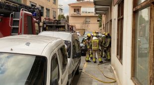 Els Bombers després d'apagar les flames, a l'entrada de l'immoble