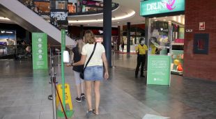 Clients utilitzant gel hidoalcohòlic a l'entrada de l'Espai Gironès