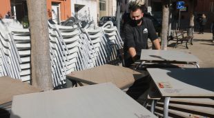 El propietari del bar El Caixer de Vilobí, Jordi López, recollint les cadires i taules