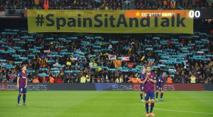 Cartell de Tsunami Democràtic amb el lema 'Spain, sit and talk!' a l'inici del clàssic al Camp Nou darrere dels jugadors