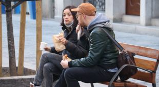 Una parella esmorzant en un banc públic de la Rambla de Girona un cop superada l'hora d'obertura, aquest matí