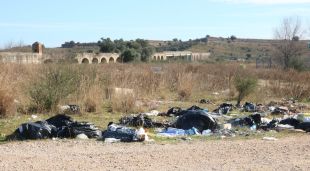 Restes de deixalles a la zona amb els arcs del Castell de Sant Ferran de fons