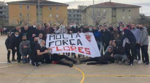Els amics d'en Ramon Flores amb el cap rapat i amb una pancarta de suport al jove