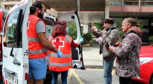 Voluntaris de la Creu Roja distribuint aliments a persones sensesostre a Girona (arxiu)