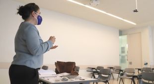 Una professora de la UdG fent classe virtual en una aula buida