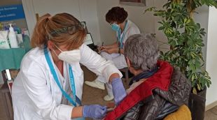 Una sanitària vacunant una pacient amb esclerosi múltiple