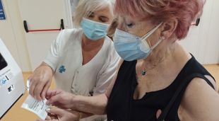 Una pacient atesa per una professional sanitària, que li explica el nou sistema de gestió de cites als hospitals Trueta i Santa Caterina