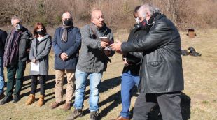 Un dels membres de l'Amical Antics Guerrillers de Catalunya entrega el llibre del guia Josep Gros al director del Memorial Democràtic, Vicenç Villatoro