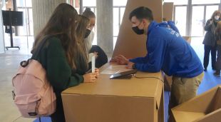 Un estudiant d'un grau de Ciències Econòmiques de la UdG explica com funcionen els estudis a tres alumnes de secundària a la fira de l'Expojove